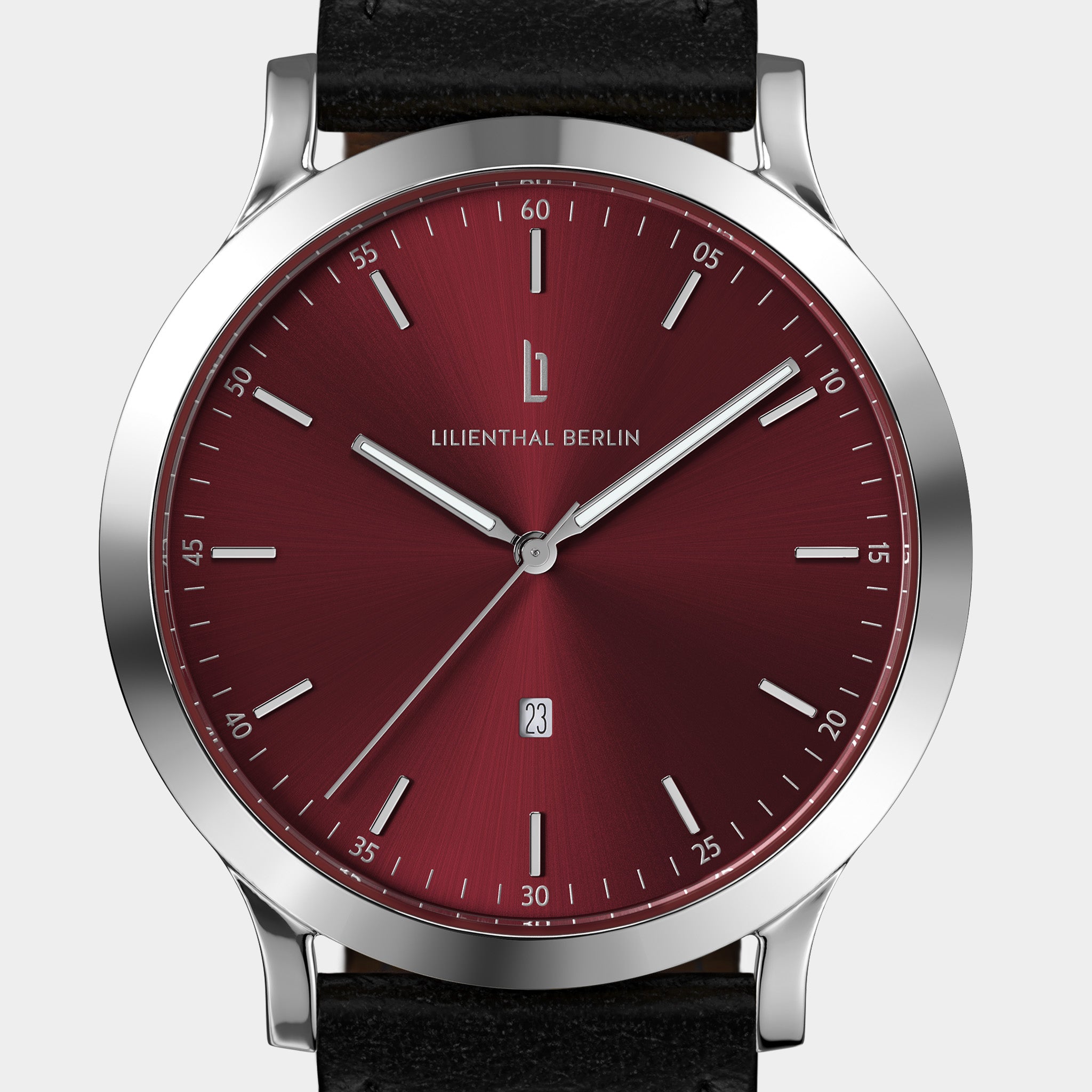 Minimalist wristwatch with a sunburst red dial, silver case, and black leather strap