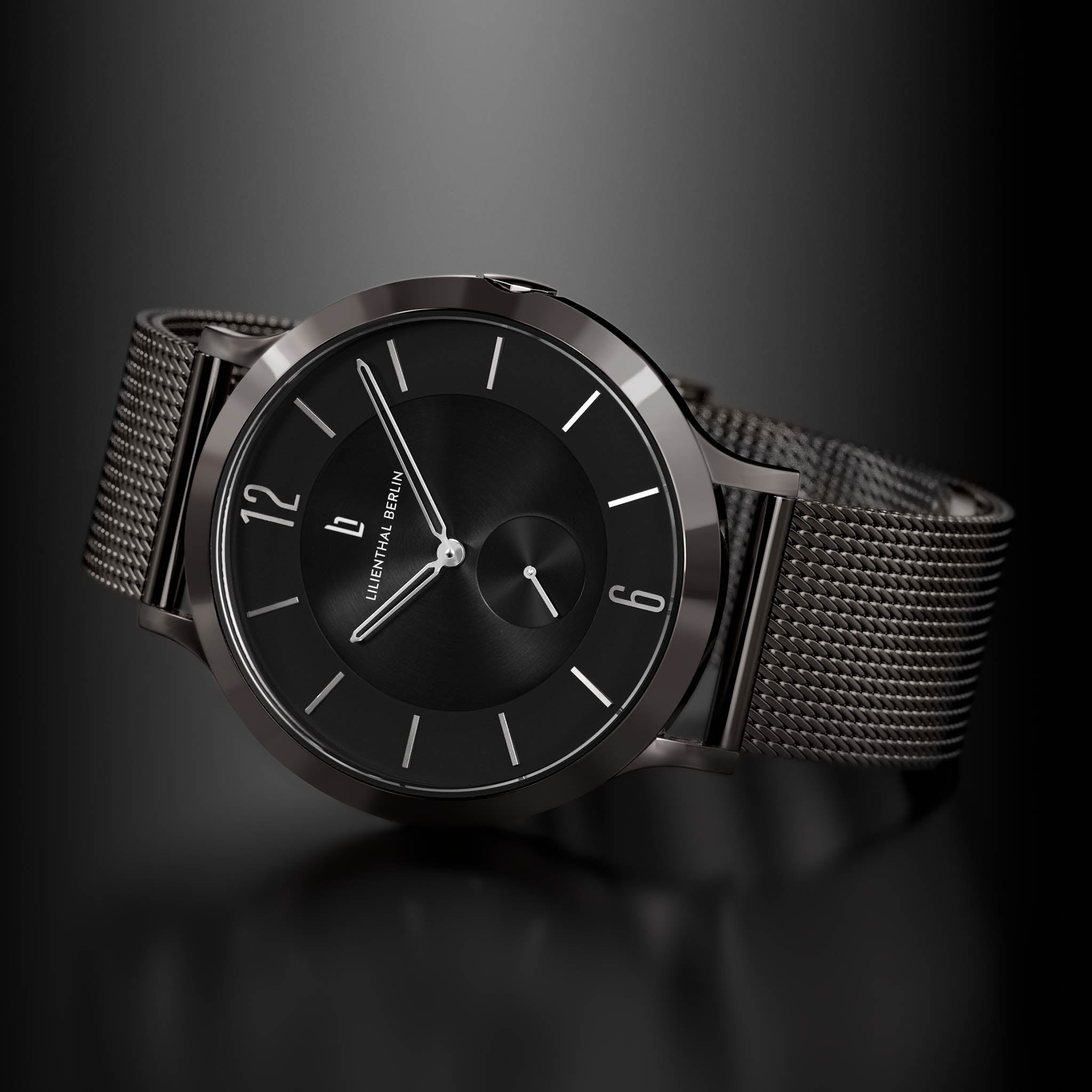 Minimalist black wristwatch with mesh strap and sleek dial on dark background