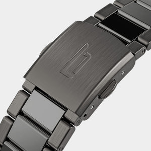 Close-up of brushed metal watch clasp with engraved logo and stainless steel bracelet