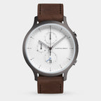 Minimalist men's wristwatch with brown leather strap, white dial, chronograph subdials, and date display