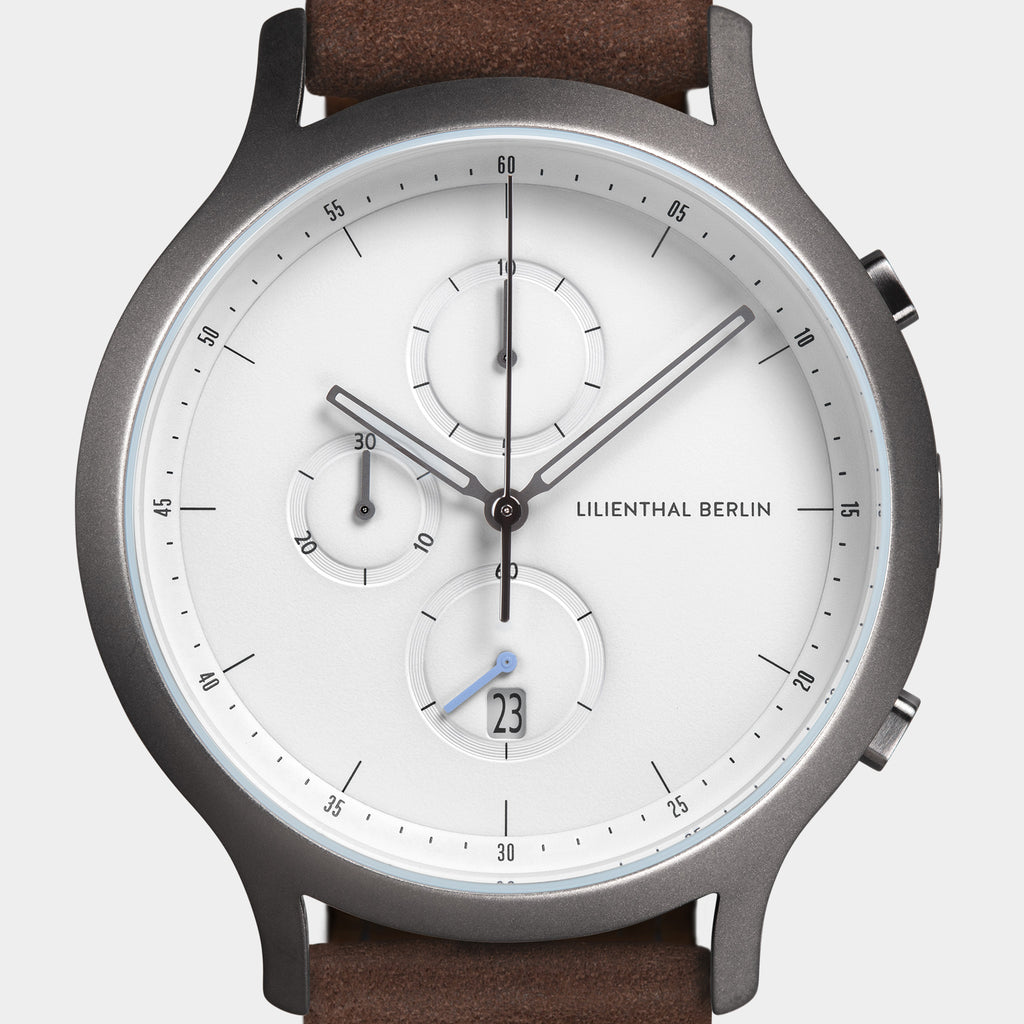 Modern chronograph watch with white dial, subdials, date display, stainless case, brown strap