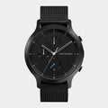 Black stainless steel chronograph watch with mesh strap and minimalist dial on white background