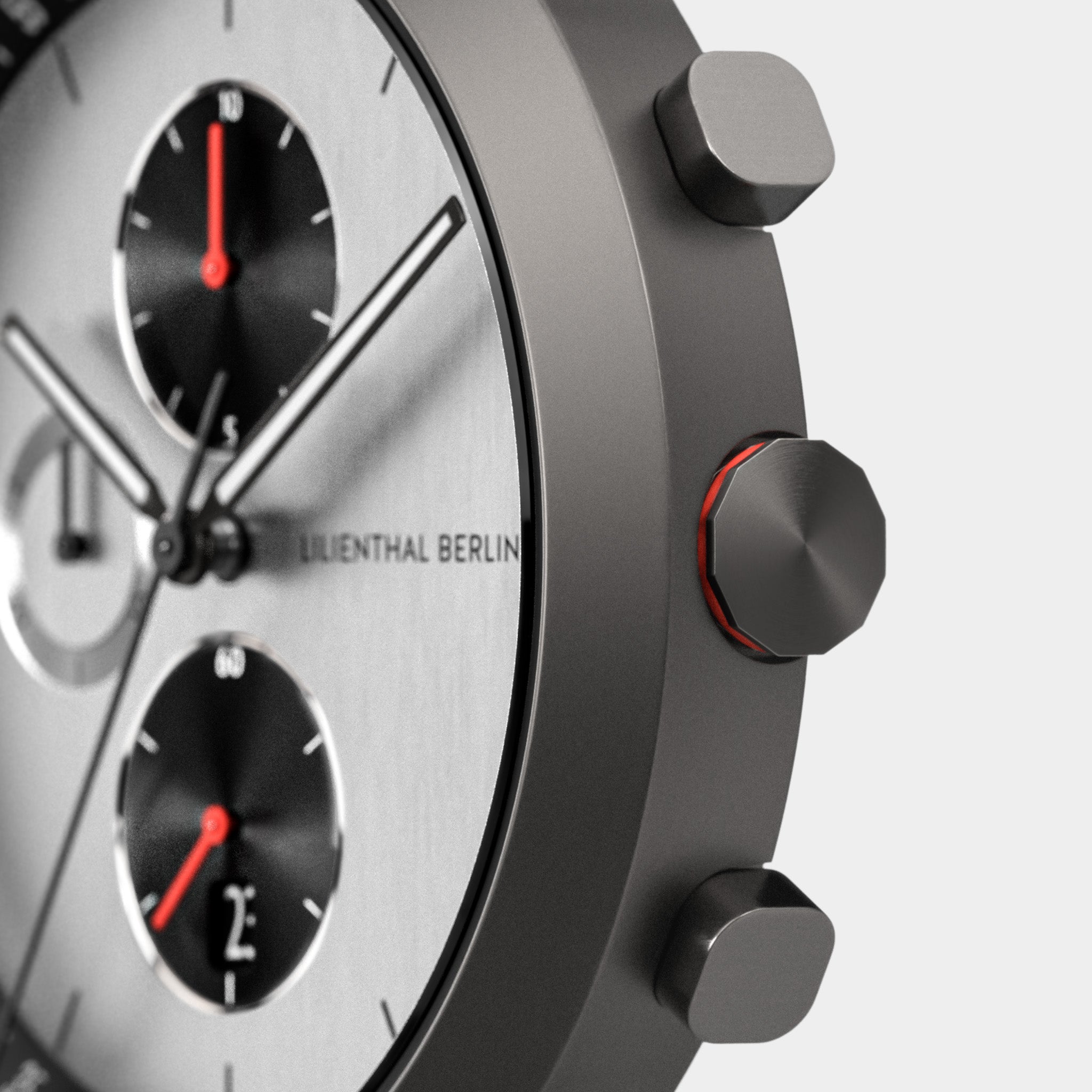 Close-up of a modern chronograph watch with stainless steel case and subdials, red accents