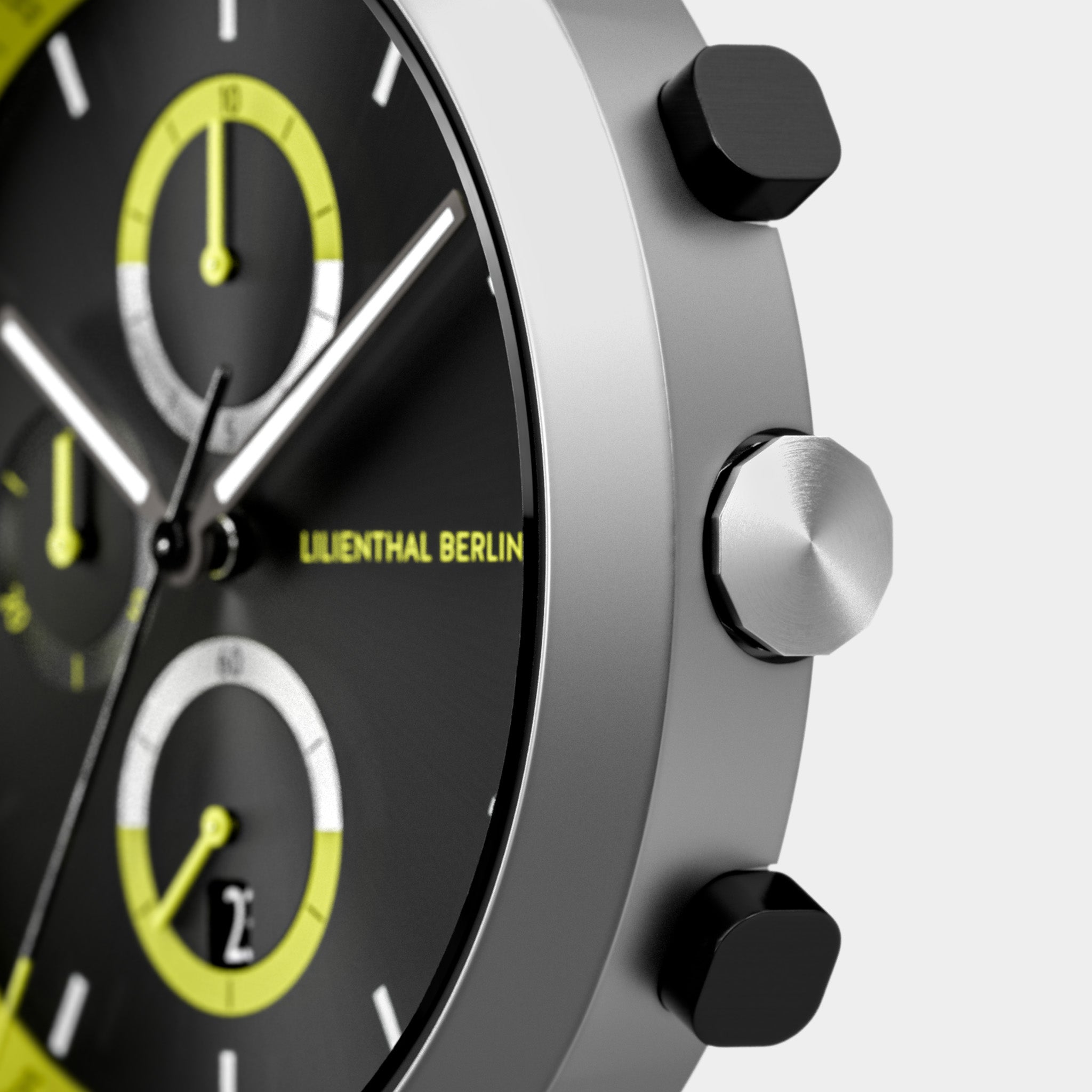 Close-up of modern chronograph watch with black dial, yellow accents, and silver case.