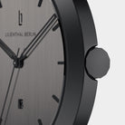 Close-up of minimalist black watch with brushed metal dial and date window