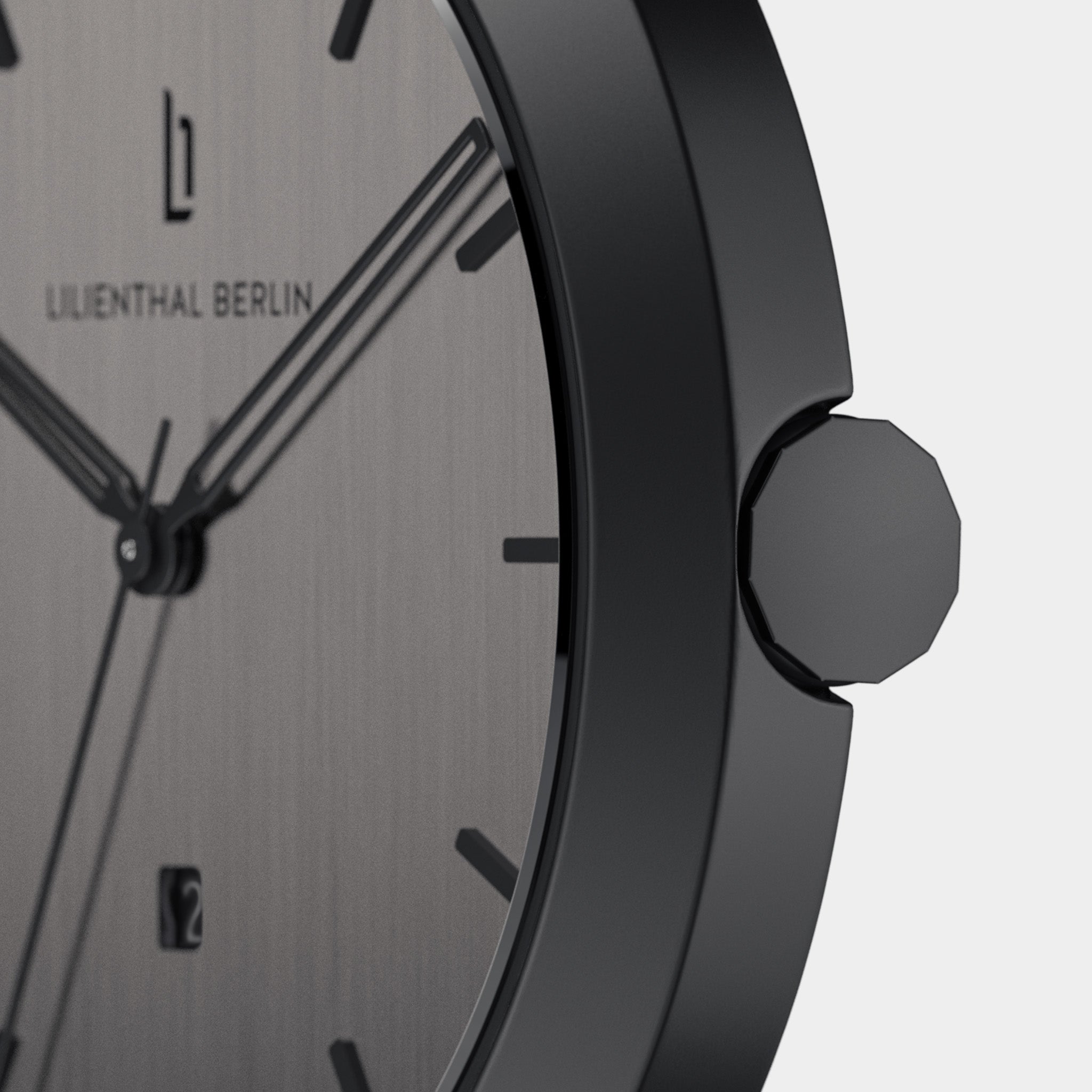 Close-up of minimalist black watch with brushed metal dial and date window