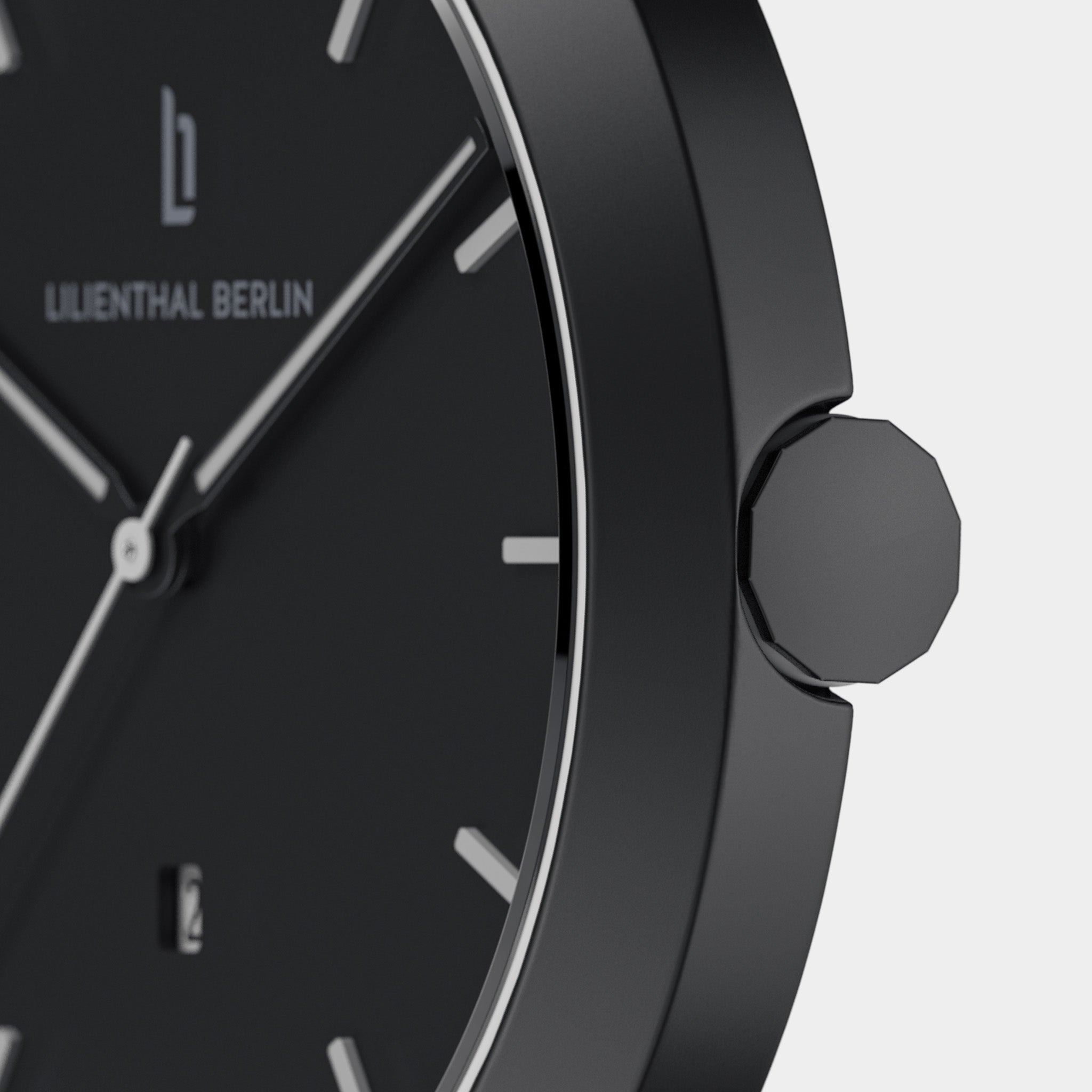 Close-up of minimalist black wristwatch with silver hour markers and geometric crown