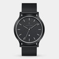 Minimalist black wristwatch with mesh strap and date display on white background