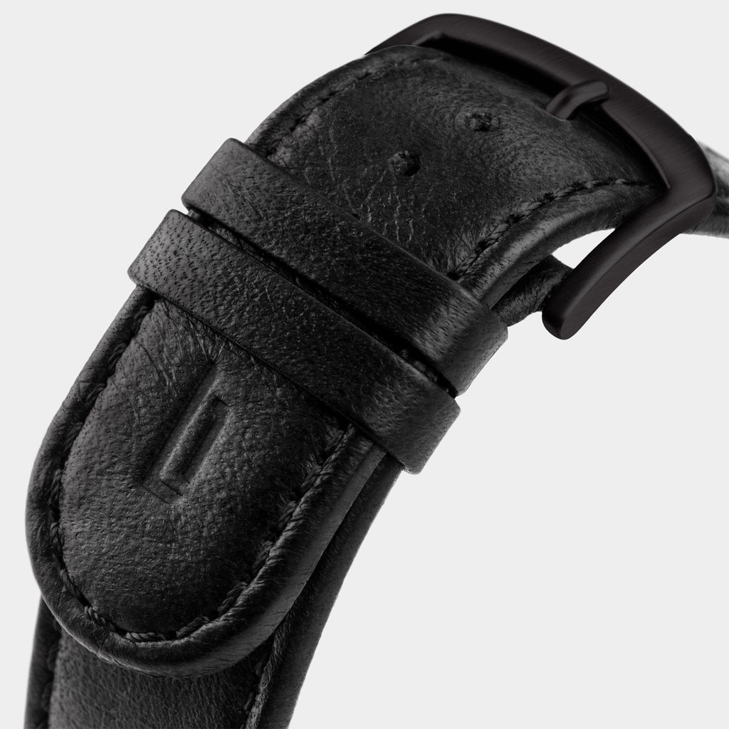 Close-up of black leather watch strap with matte black buckle