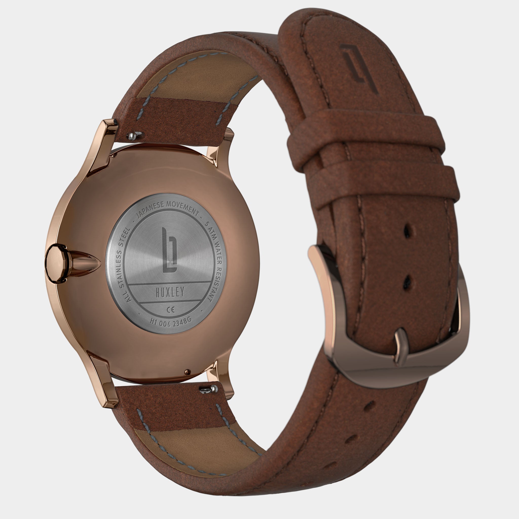 Back view of a rose gold case watch with brown leather strap and engraved stainless steel back