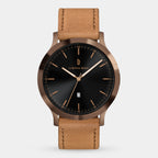 Minimalist watch with black sunburst dial, rose gold details, date window, and tan leather strap