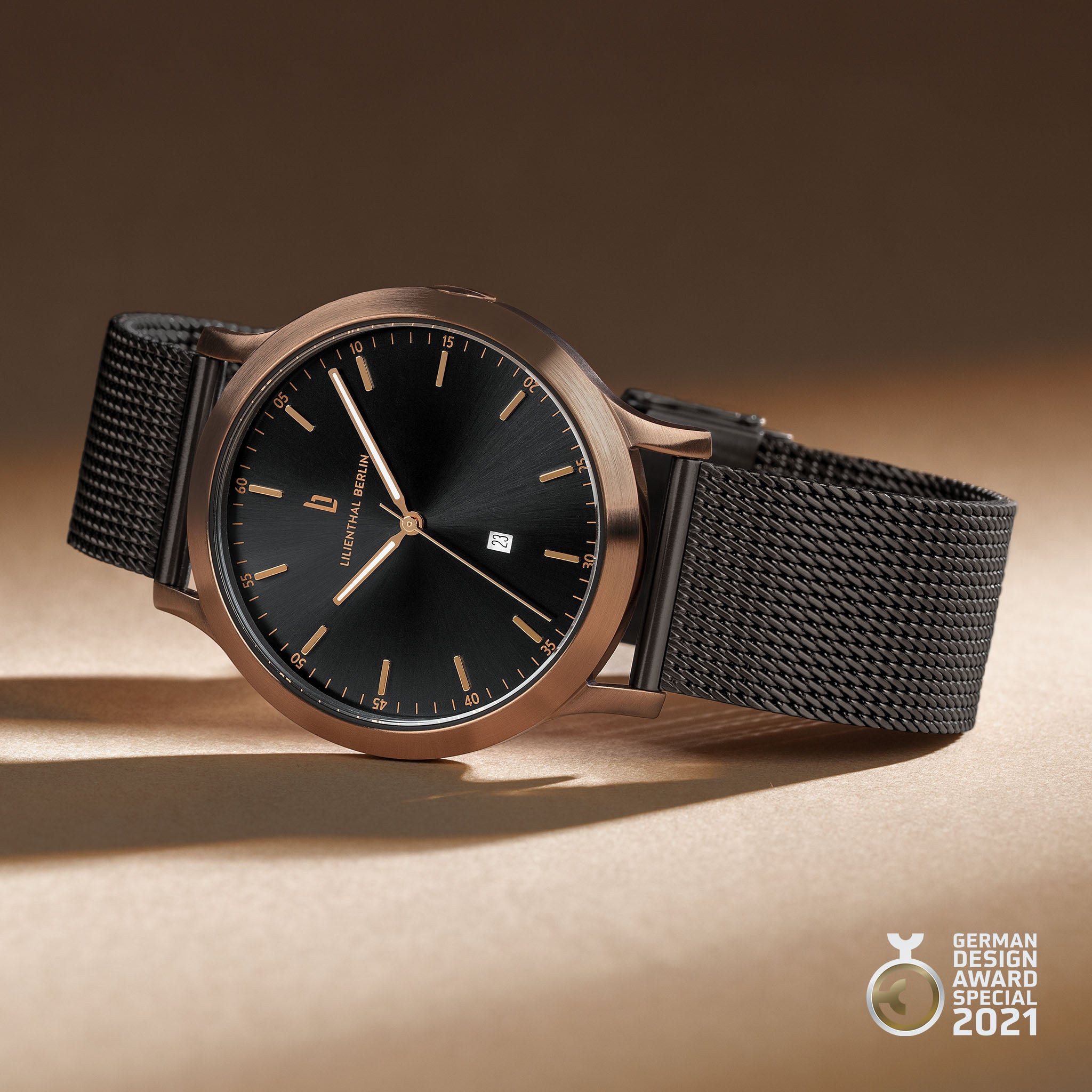 Minimalist black watch with rose gold case, mesh strap, and German Design Award 2021 badge
