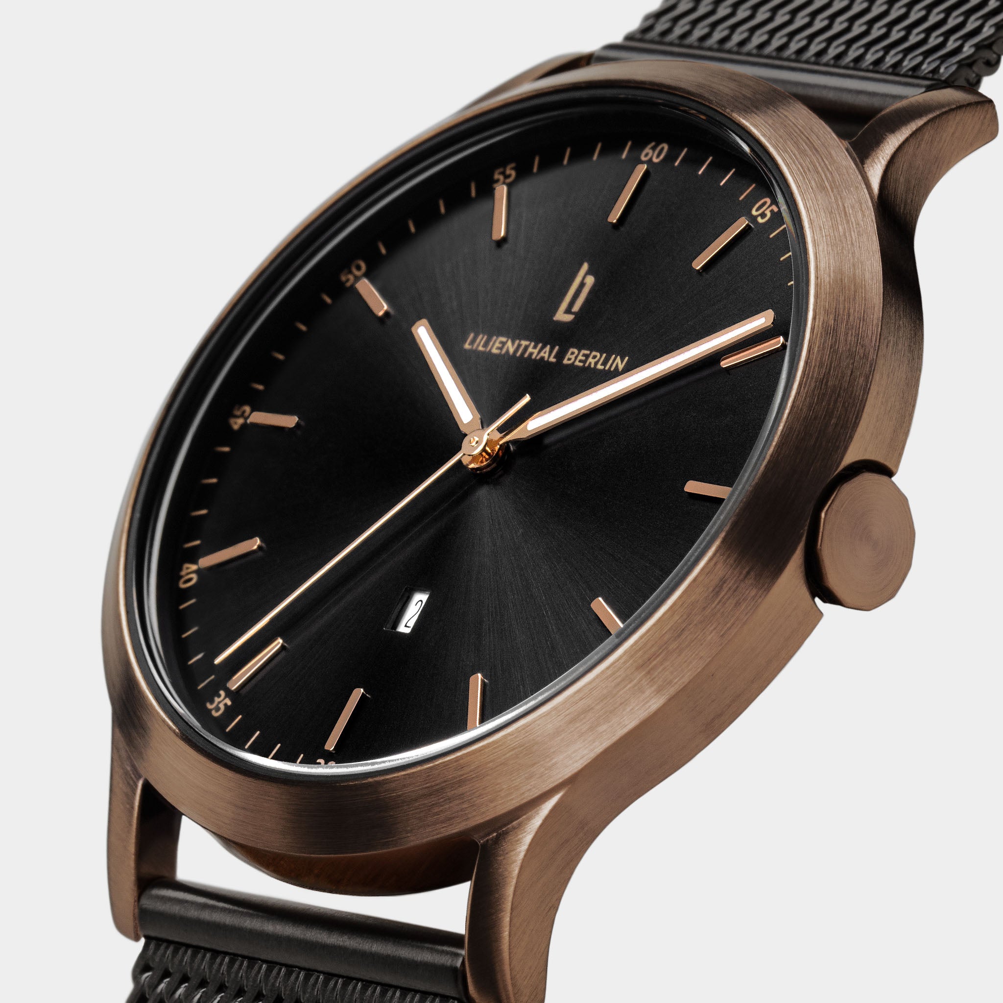 Elegant wristwatch with black dial, gold hour markers, mesh strap, and minimalist design