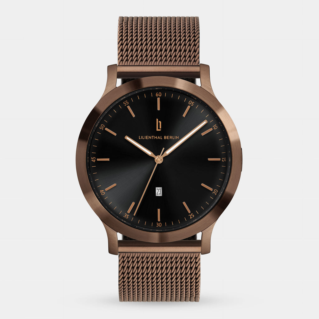 Minimalist bronze mesh strap watch with black dial and gold markers on white background