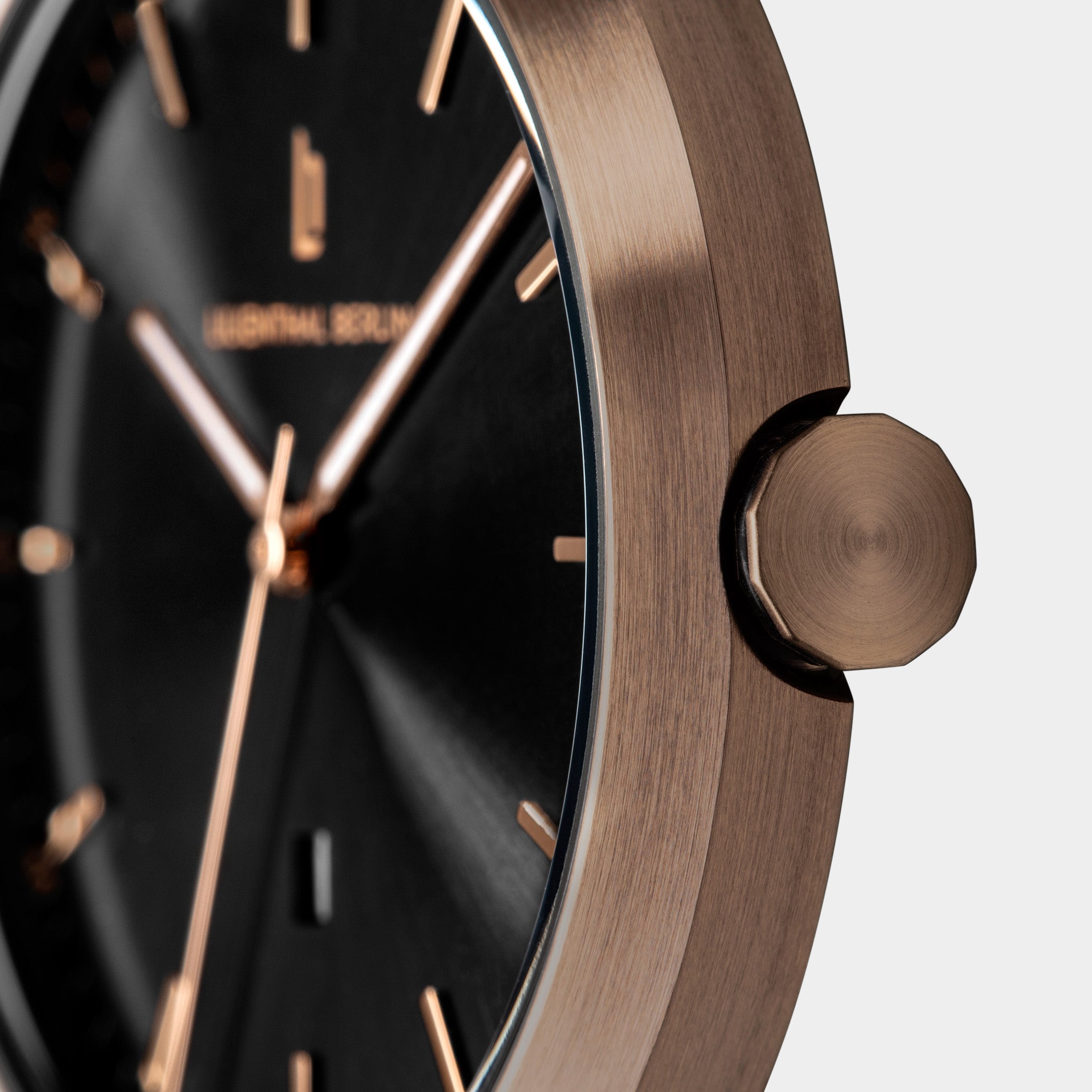 Close-up of a modern wristwatch with black dial and rose gold case and markers