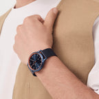 Man wearing minimalist blue wristwatch with mesh strap and copper bezel