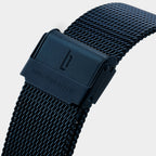 Black mesh metal watch strap with clasp and engraved logo, detail view