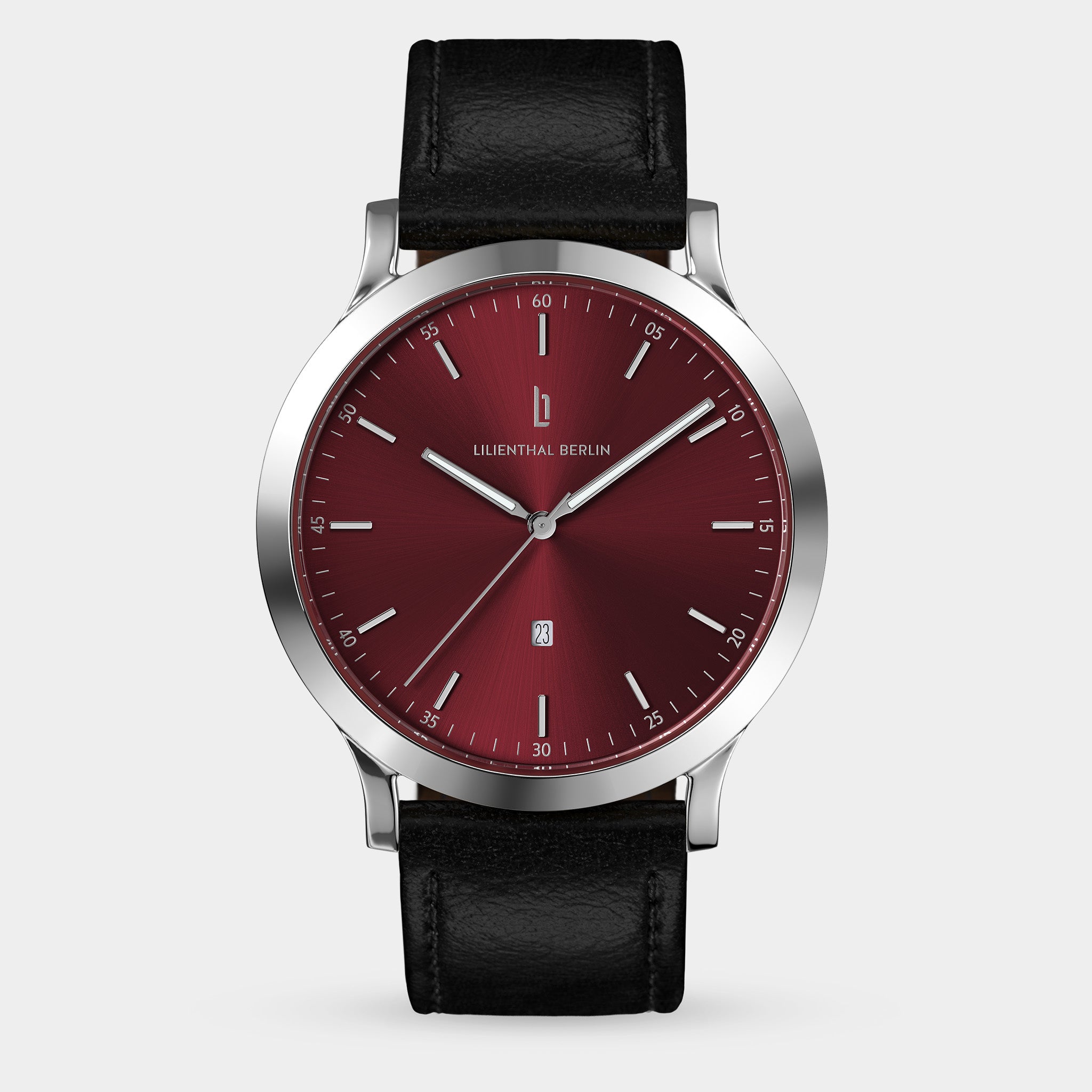 Minimalist wristwatch with a red dial, silver case, and black leather strap on white background
