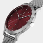 Silver mesh watch with red dial, minimalist hour markers, and modern design