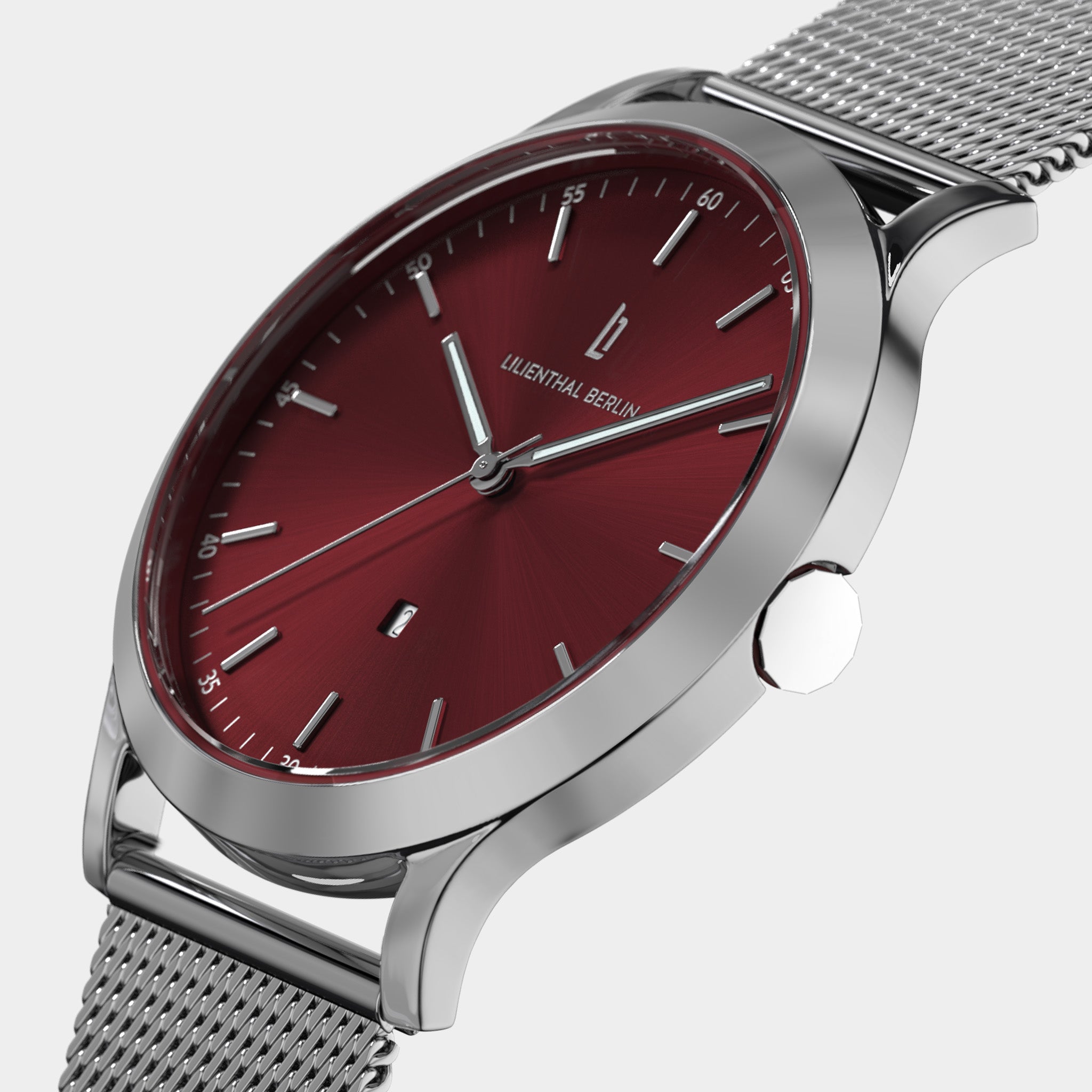 Silver mesh watch with red dial, minimalist hour markers, and modern design