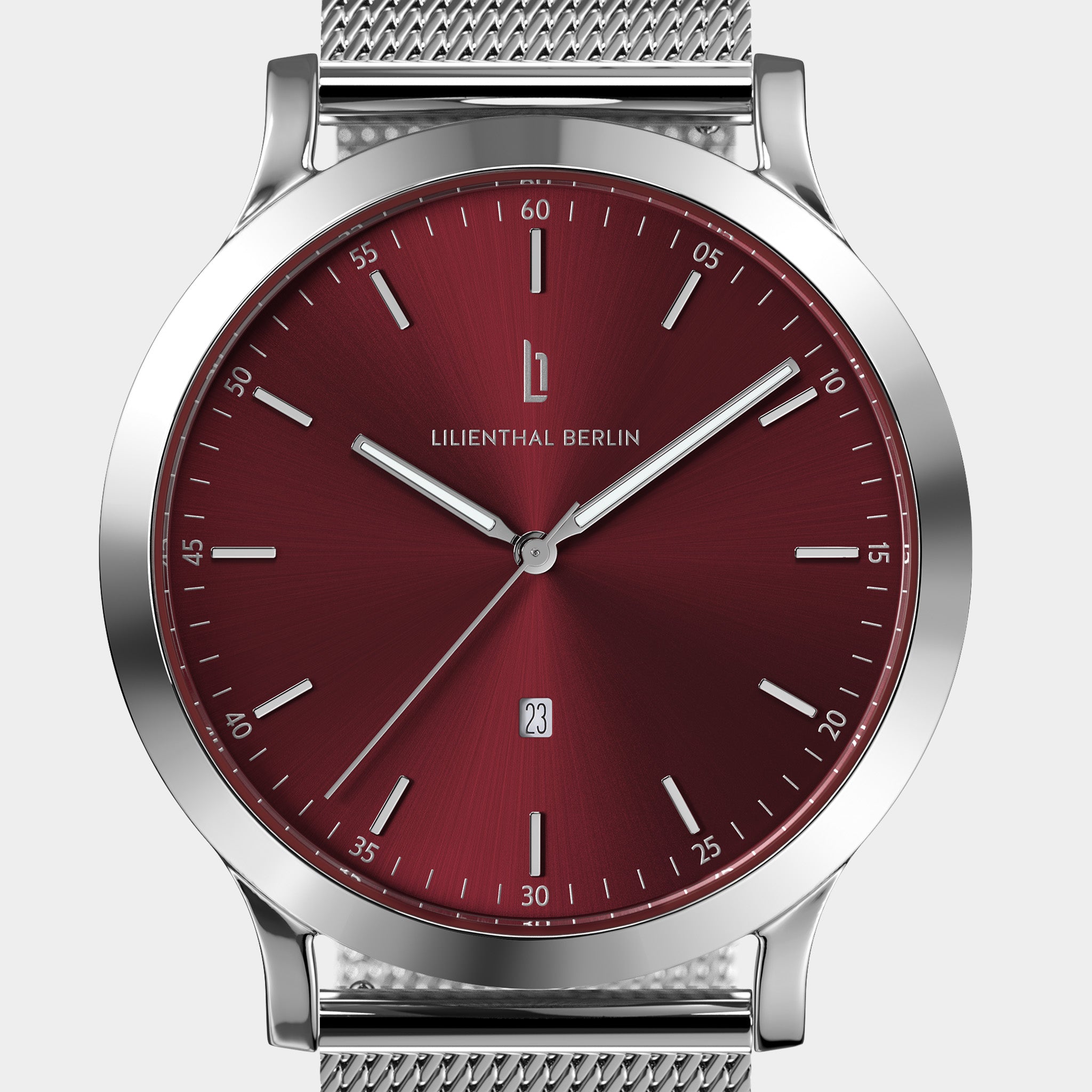 Silver mesh strap watch with a red sunburst dial, minimalist markers, and date display