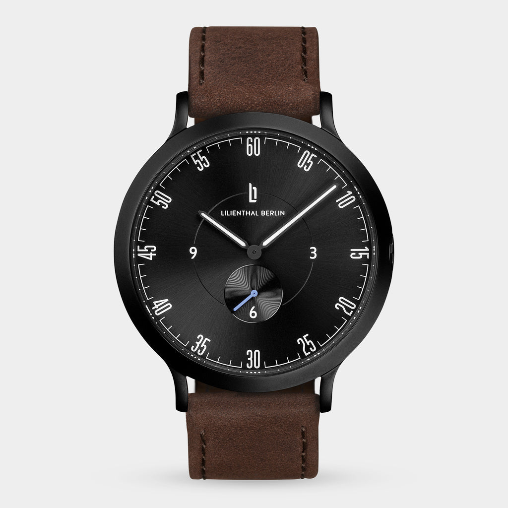 Minimalist black dial wristwatch with brown leather strap and subdial, modern design