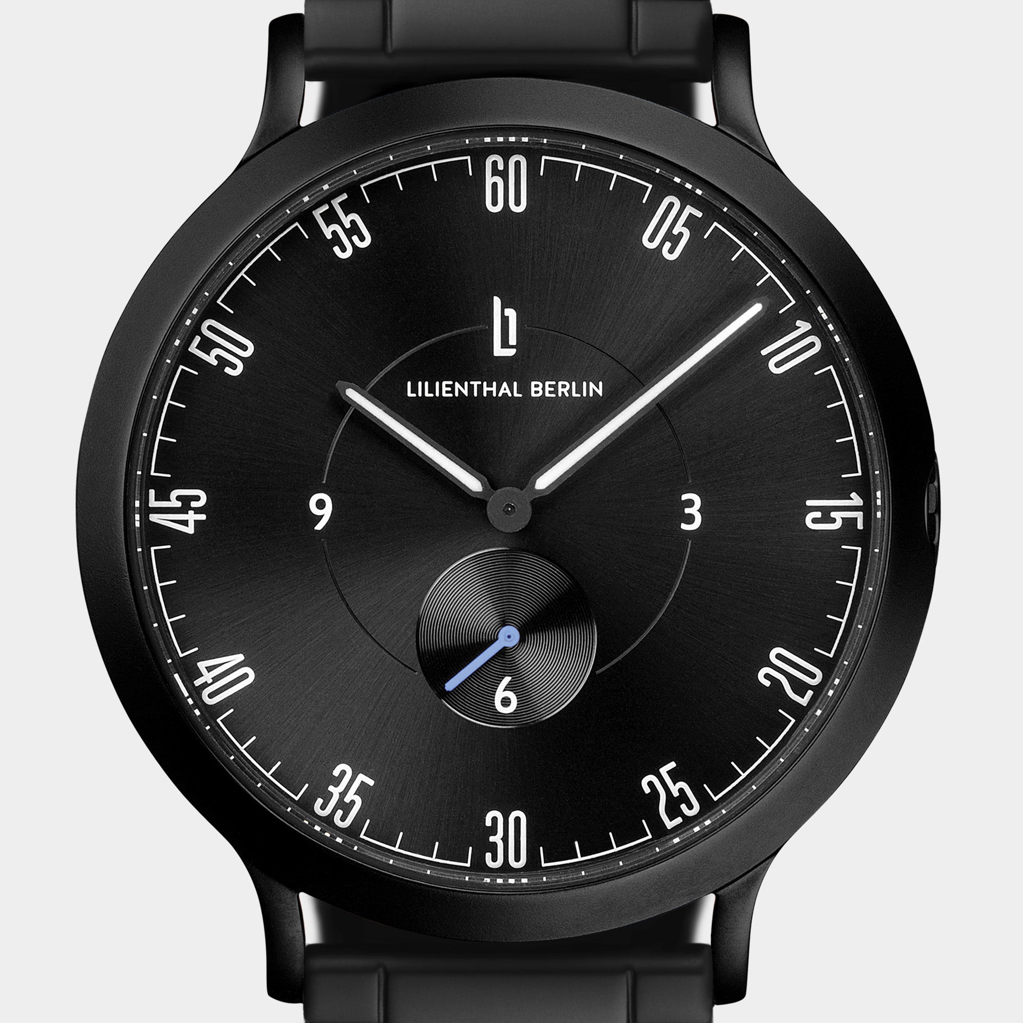 Minimalist black analog watch with sleek dial, bold numerals, and subdial, close-up view.