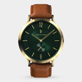 Gold case watch with emerald green dial and brown leather strap on white background