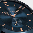Close-up of modern dark blue watch face with rose gold hands and minimalist markers